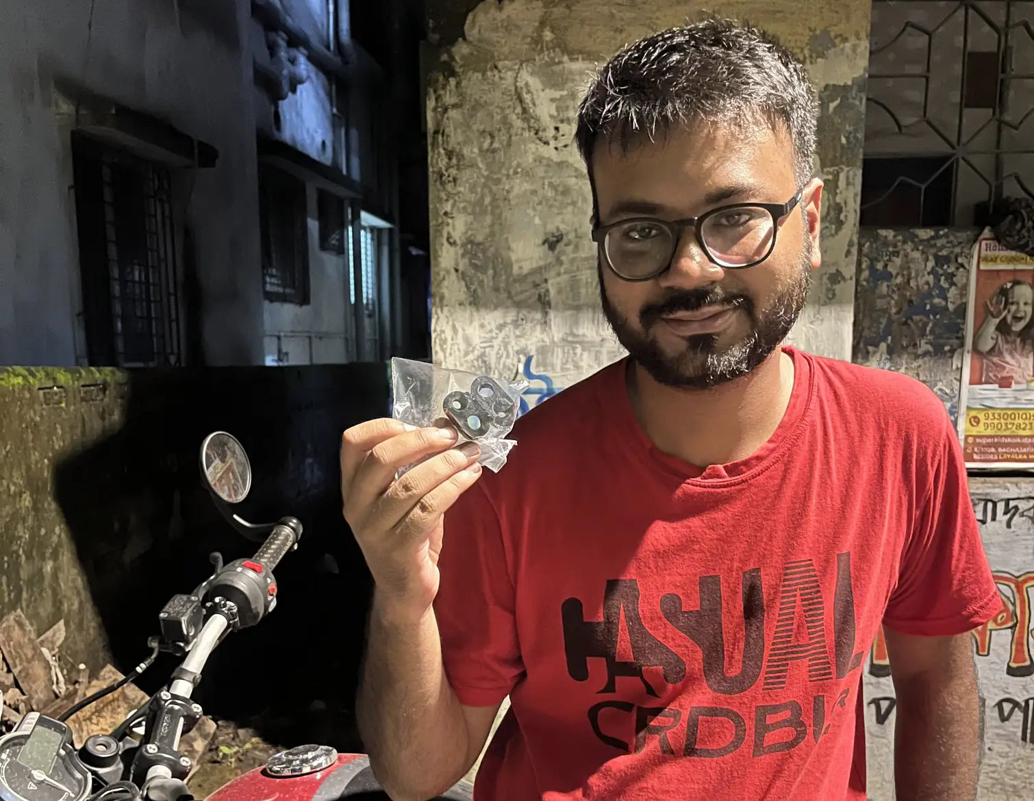 Rider holding a sealed pair of MotoNyx indicator adapters beside his Triumph 400