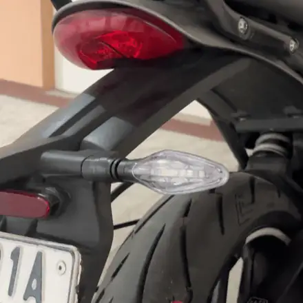 Adapter and aftermarket indicator fitted on a Triumph 400 — rider clip